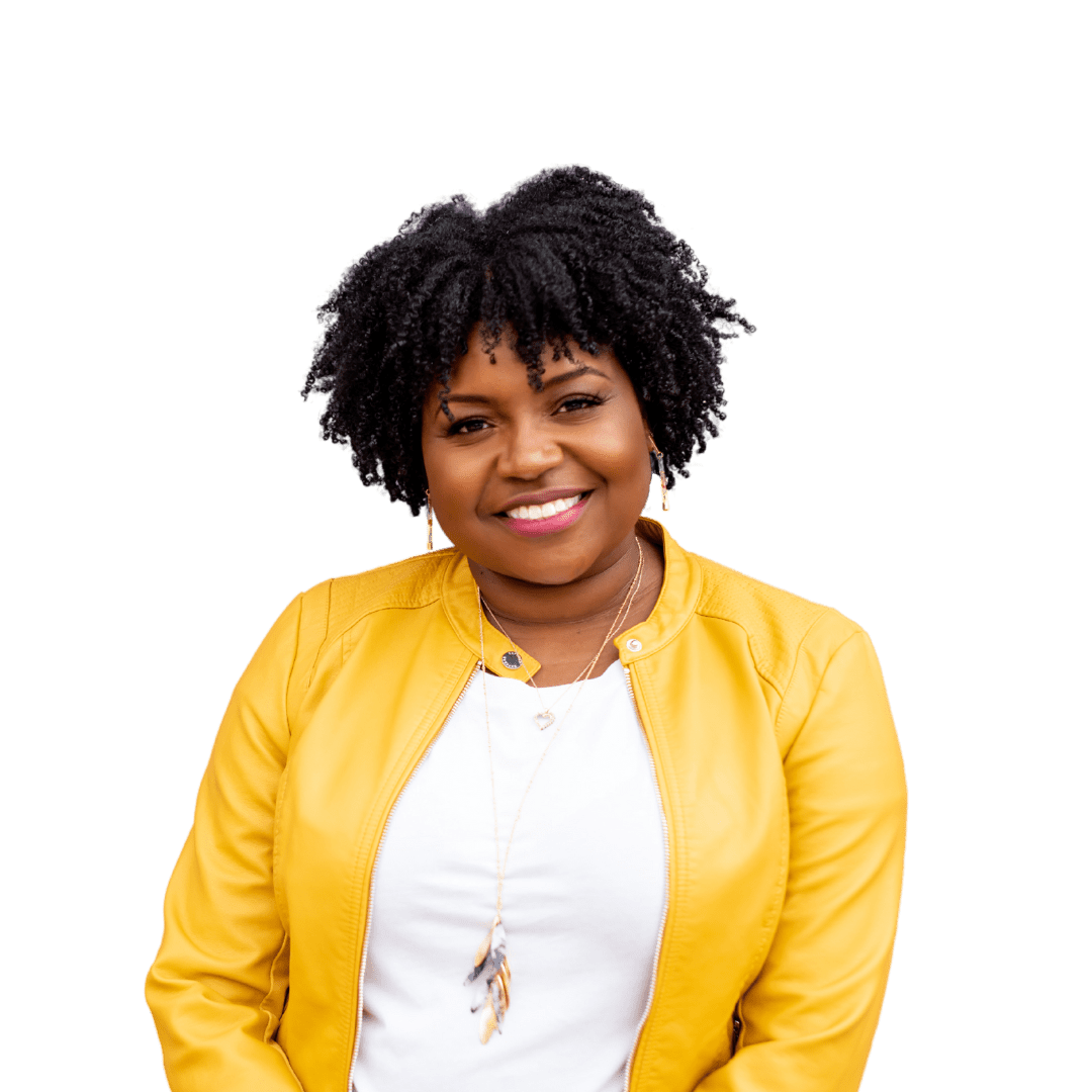 Smiling Black female therapist wearing a white button-down shirt and jeans, standing with arms crossed, representing grief counseling, therapy for women’s issues, and workplace stress support in Georgia (30080, 30339, 30067, 30213).